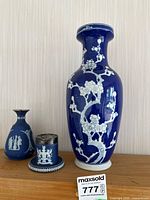 Front view of three ceramic pieces on shelf