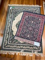 Both rugs laid flat; shows full designs and fringe