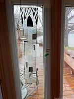 Full view of vertical stained glass panel hanging in doorway