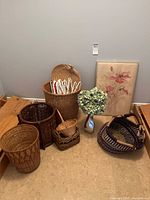 Group shot showing all baskets, metal vase with flowers, and framed artwork