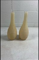 front view of both ribbed vase-shape candles standing upright