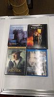 Front view of four movie cases: The Revenant Blu-ray, Robin Hood Prince of Thieves DVD, Road to Perdition DVD, Sherlock Holmes Game of Shadows Blu-ray