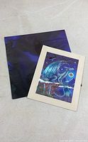 Art print and folded blue poster displayed together