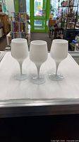 Front view of three milk glass goblets standing side by side