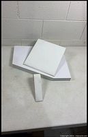 Three white jewelry display risers arranged together