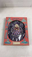 Front view of doll inside branded box