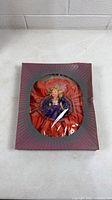 Closed box showing doll through window