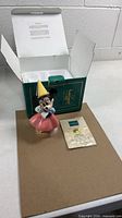 Figurine, certificate and open original box displayed together