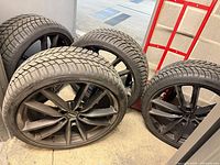 All four wheels and tires standing upright showing spoke design and tread