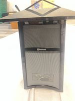Front view of AR AWSBT4 speaker showing grille and Bluetooth logo