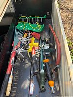 Drawer view showing assortment: aerator sandals, cultivator heads, multiple hand tools