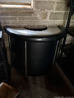 Front view of black curved bar with chrome legs and padded top