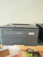 Front and side view of Brother monochrome laser printer on shelf