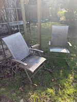 Two brown-taupe metal frame rocking chairs on grass