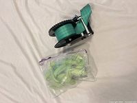 Winch with green strap and mesh bag of straps
