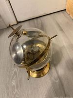 Overall view of acrylic globe thermometer with brass pins and internal dial
