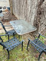 table and two chairs view showing glass top, lattice seats, umbrella hole