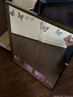 Front view of square mirror showing wood frame and butterfly stickers