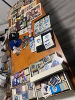 overview of entire collection on table: cards, newspapers, caps, mug, binder