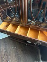 Open divided drawer beneath glass display area