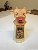 Full view of Moo-Cow Creamer showing cow head lid, label and colors