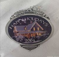 Front view showing house image, Happy Holidays 2004 text, pewter frame with holly