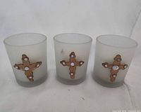 Front view of three frosted glass votive holders