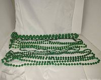 Full view of eight green bead necklaces laid out