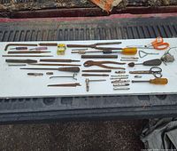 Overall view of all antique tools laid out on white board