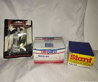 Three packaged automotive parts: Eagle blister pack, CarQuest BG3144 box, Stant thermostat 14119 box