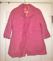 Front view of magenta girls coat hanging, shows overall style and condition