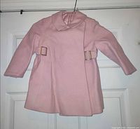 Full front view of pink girls coat hanging on door