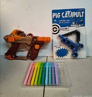 Entire lot showing toy blaster, Pig Catapult package, pen set