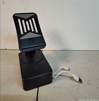 Front angled view of phone holder on speaker base with cable