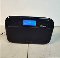 Front view of Insignia HD portable radio powered on displaying 98.9