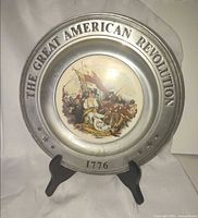 Front view showing raised lettering, stars, 1776 date and central battle illustration