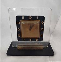 Front view of acrylic desk clock showing dial and numerals