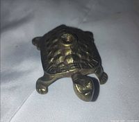 Angled top view of brass turtle showing threaded hole and leg details