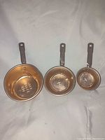 Front view of three measuring cups