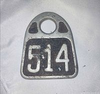 Front view of Hasco cast aluminum cow tag showing number 514