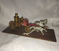 Full view of fire wagon set on base showing horses and wagon