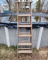 Full front view of wooden ladder leaning against pool wall