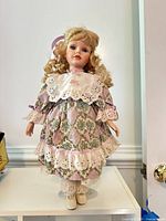 Full view of doll on stand showing dress and overall appearance