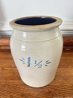 Front view of stoneware crock showing ivory glaze, blue capacity marking, brown rim