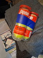 Two Penn Medalist cans taped together on grey fabric