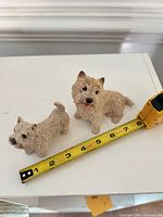Both Westie figurines with measuring tape for scale