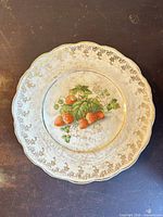 Front view of plate showing strawberry motif and gold rim