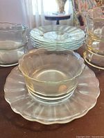 Group view of stacked clear glass bowls and plates