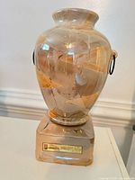 Front view of marbled ceramic decanter on square base