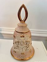 Full view of pink porcelain bell decanter showing handle, relief design and gold trim